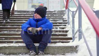 穿着蓝色<strong>羽绒服</strong>的少年在城里迷路了。 他坐在冰冷的楼梯上，环顾四周。